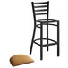 A Lancaster Table & Seating black ladder back bar stool with light brown vinyl padded seat.