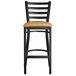 A Lancaster Table & Seating black ladder back bar stool with light brown cushion.