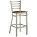 A Lancaster Table & Seating metal ladder back bar stool with a wooden seat.