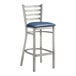 A Lancaster Table & Seating metal bar stool with navy blue vinyl padded seat.