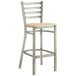A Lancaster Table & Seating metal bar stool with a natural wood seat.