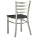 A Lancaster Table & Seating metal ladder back chair with a black wood seat.