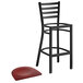 A Lancaster Table & Seating black metal ladder back bar stool with mahogany wood seat.