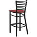 A black Lancaster Table & Seating ladder back bar stool with a mahogany wood seat.
