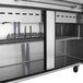 A stainless steel Turbo Air sandwich prep table with two glass doors.