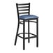A Lancaster Table & Seating black ladder back bar stool with a navy blue padded seat.