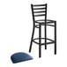 A Lancaster Table & Seating black ladder back bar stool with navy blue vinyl padded seat.