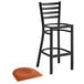 A Lancaster Table & Seating black ladder back bar stool with a cherry wood seat next to it.