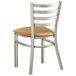 A Lancaster Table & Seating metal restaurant chair with a light brown vinyl padded seat and ladder back.