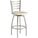 A Lancaster Table & Seating swivel bar stool with a driftwood seat and metal frame.