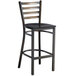 A black metal Lancaster Table & Seating bar stool with a black wooden seat.