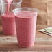 A close-up of a pink smoothie being poured into a Fabri-Kal plastic cup.