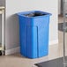 A Toter blue 35 gallon square trash can sitting on a floor in a corporate office cafeteria with a bag inside.