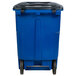 A blue Toter rectangular trash can with black wheels.