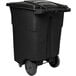 A black Toter rectangular rotational molded wheeled trash can with casters.