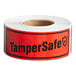 A roll of red TamperSafe labels with black text.