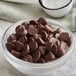 A white bowl of Guittard 41% Semi-Sweet Chocolate 1M Baking Chips.