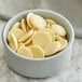 A bowl of Guittard Creme Francaise white chocolate wafers.