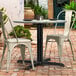 A Lancaster Table & Seating outdoor table base with chairs on a brick patio.