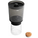 An OXO cold brew coffee maker with a glass and cork lid.