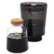 An OXO cold brew coffee maker with a glass jar filled with dark brown liquid and a black lid.