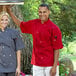 A man and woman wearing Uncommon Chef red short sleeve chef coats.