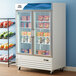 An Avantco white swing glass door merchandiser freezer with food and drinks inside.