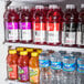 An Avantco glass door refrigerator with shelves of bottled drinks.
