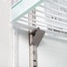 A close up of a metal shelf inside a white Avantco swing glass door refrigerator.