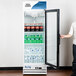 An Avantco white swing glass door refrigerator full of soda bottles.