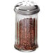 An American Metalcraft glass spice shaker with a stainless steel lid filled with red pepper flakes.