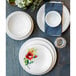 A table set with white Fiesta® dinnerware including plates and bowls.