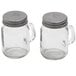 A couple of glass Mason jar salt and pepper shakers with silver metal lids.