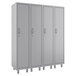 A row of four grey metal Hirsh Industries tall storage lockers with doors.