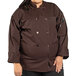 A plus size woman wearing a brown Uncommon Chef Orleans long sleeve chef coat.