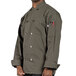 A man wearing a Uncommon Chef long sleeve olive green chef coat.