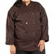 A plus size woman wearing a brown Uncommon Chef long sleeve chef coat.