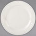 A white Tuxton china plate with an embossed design on the rim.