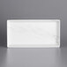 A white rectangular melamine tray with a marble design.