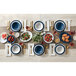 A table set with American Metalcraft Jane Casual linen melamine plates and blue bowls on a table with food and flowers.
