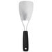 An OXO stainless steel spatula with a black handle.
