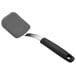 An OXO black and silver silicone cookie spatula with a handle.