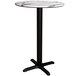 A Lancaster Table & Seating round counter height table with a white marble top and black cross base.