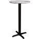 A Lancaster Table & Seating bar height table with a white marble top and black cross base.