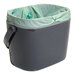 An OXO charcoal gray rectangular compost bin with green handles.