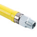 A yellow T&S gas appliance connector with a silver metal end.
