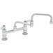 A chrome T&S deck-mounted faucet with double jointed swing nozzle and lever handles.