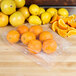 A table with plastic bags of oranges and lemons.