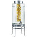A Cal-Mil glass beverage dispenser with water and lemon wedges inside.