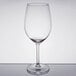 An empty Libbey wine glass on a table with a reflection.
